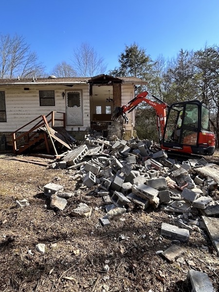 A compact loader clearing tree debris